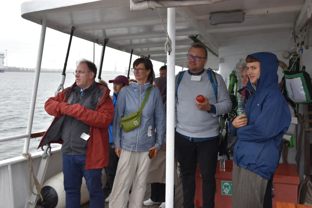 Projektpartnere kigger ud over havet fra en båd