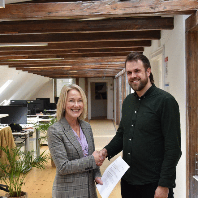 Two people shaking hands and smiling