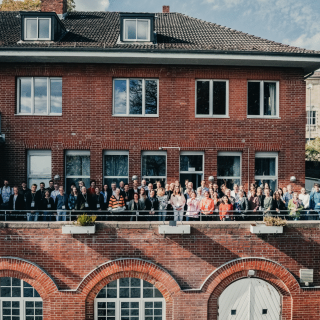 Alle deltagerne fra POSEIDONs midtvejskonference, der står samlet på en terrasse
