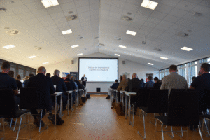 a room with a dias show and lots of people